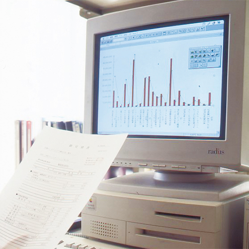 1990年代のMacと目の前で資料を見ている様子